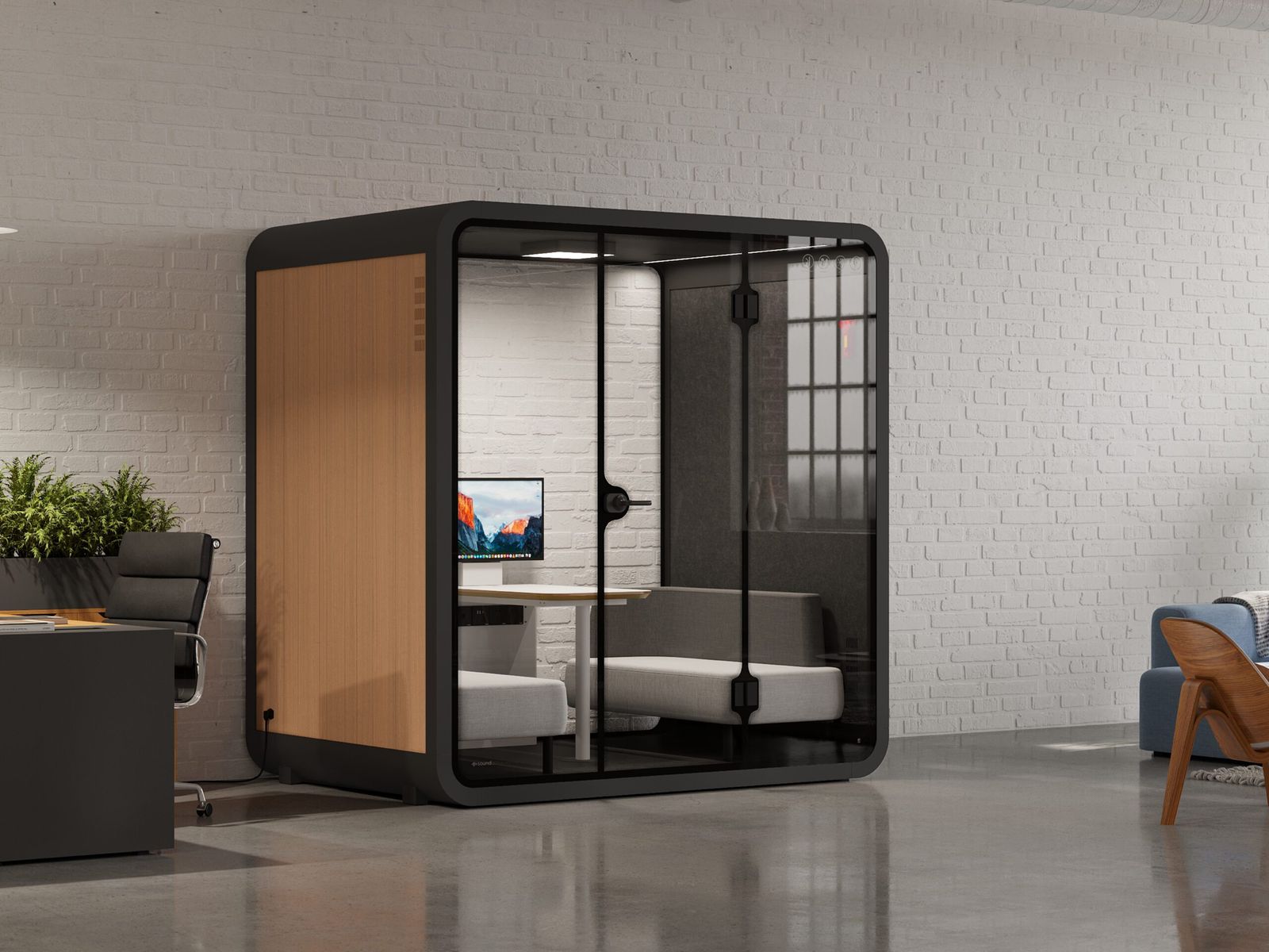 Glazed single-person work pod standing against a brick wall