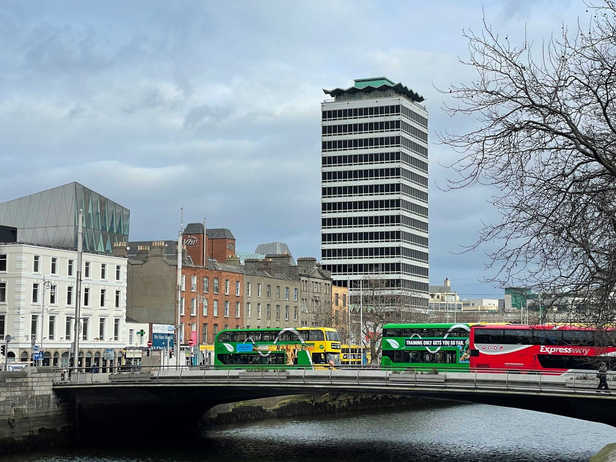 Liberty Hall seen across the Liffey with buses crossing the bridge