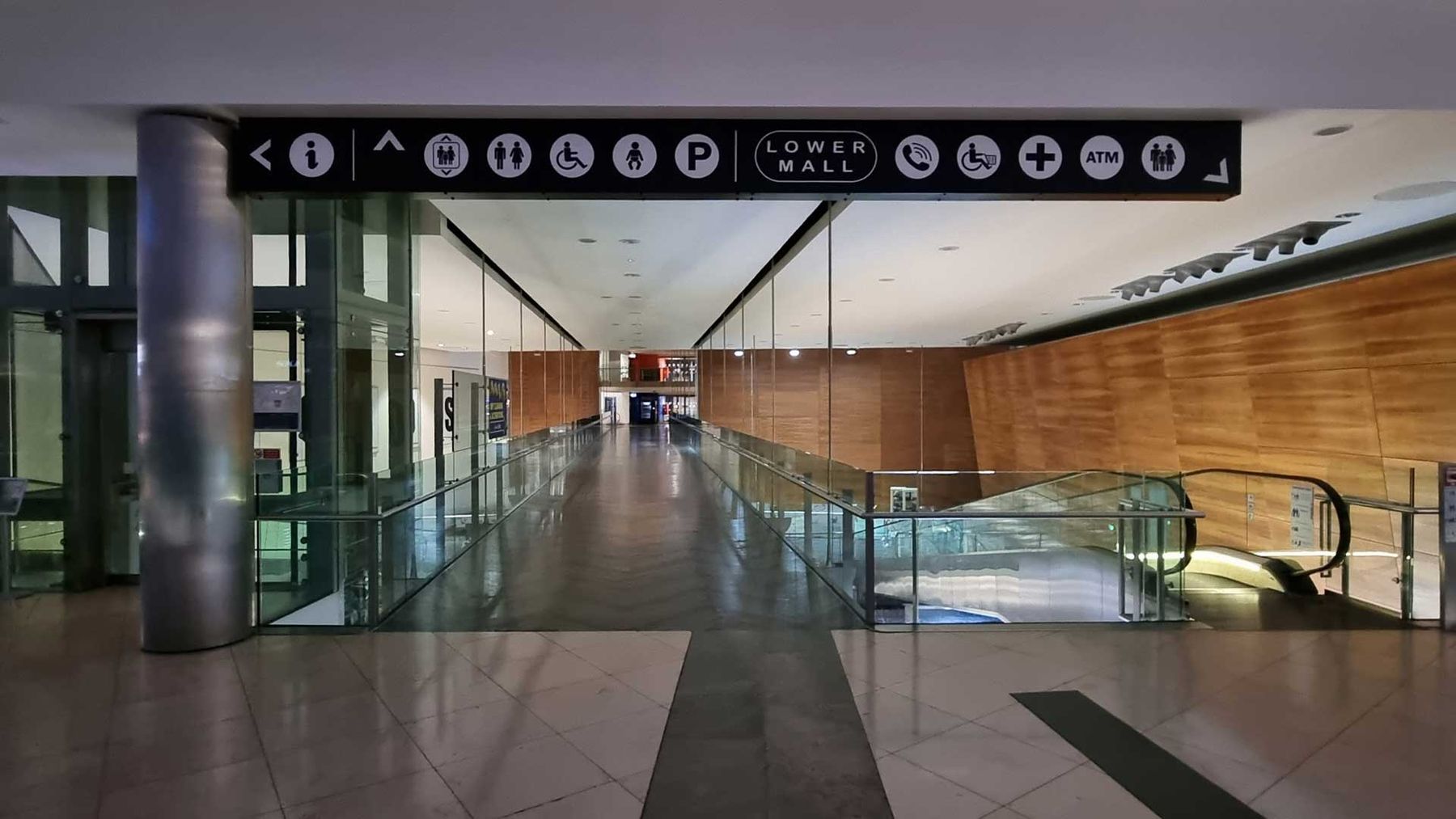 Overhead directional sign reading Lower Mall above a shopping centre concourse