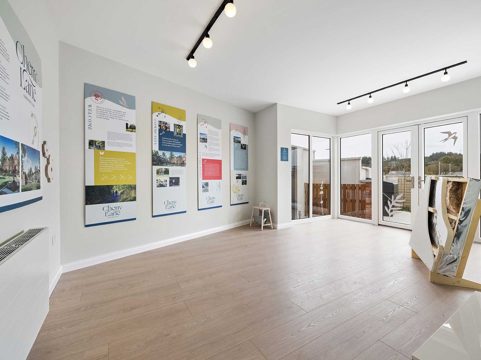 Bright marketing suite with display boards and a Cherry Lane panel